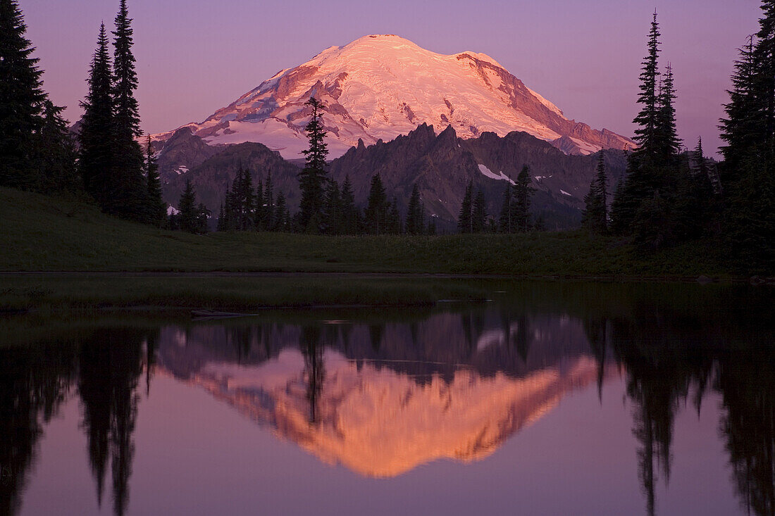 Der schneebedeckte Mount Rainier spiegelt sich bei Sonnenaufgang im Tipsoo Lake, Mount Rainier National Park, Washington, Vereinigte Staaten von Amerika