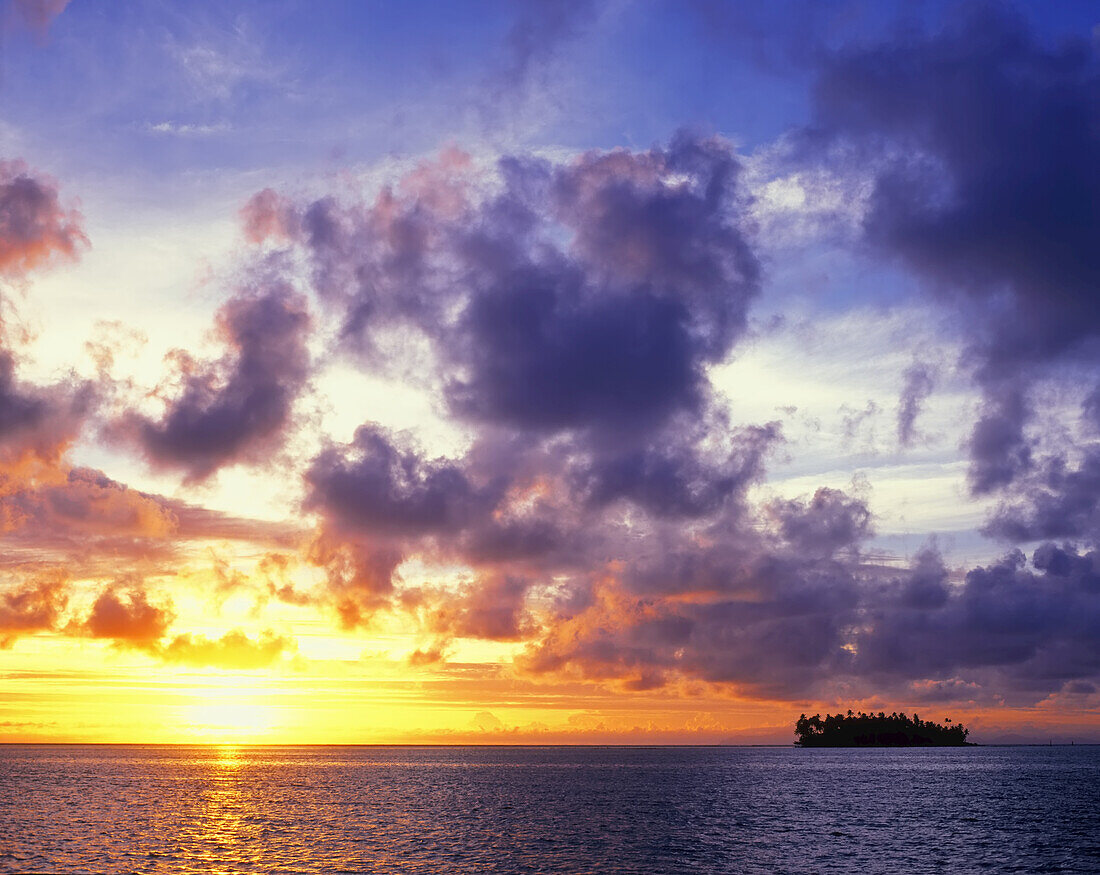 Dramatischer Sonnenuntergang über einer kleinen Insel im Südpazifik, Bora Bora, Französisch-Polynesien