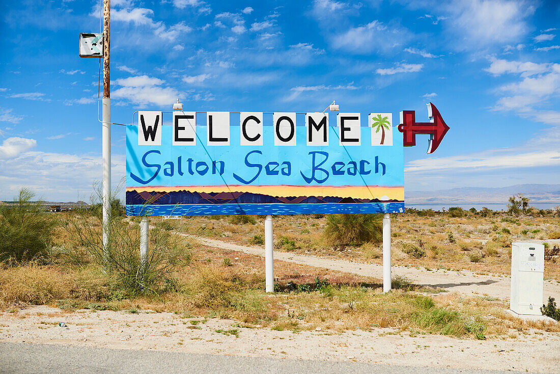 Welcome to Salton Sea Beach sign against background of Salton Sea and Mountains,Salton City,California,United States of America