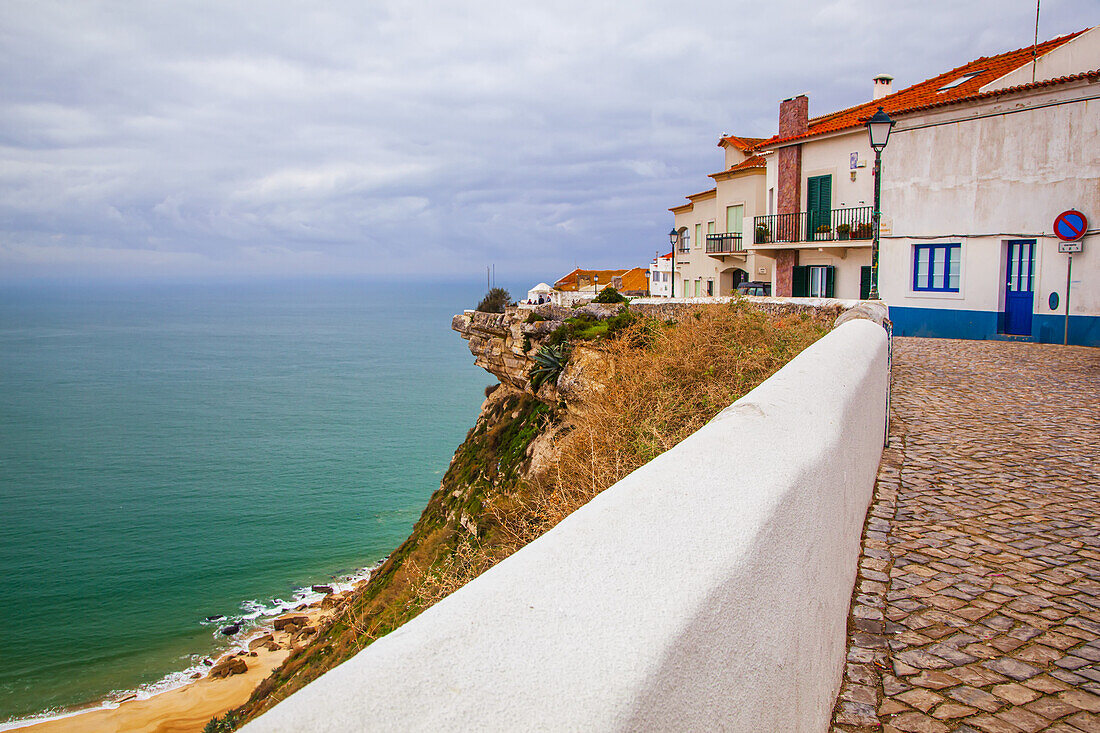 Bunte Häuser oberhalb einer Klippe an der Küste von Nazare, Portugal, entlang des Atlantiks, Nazare, Portugal