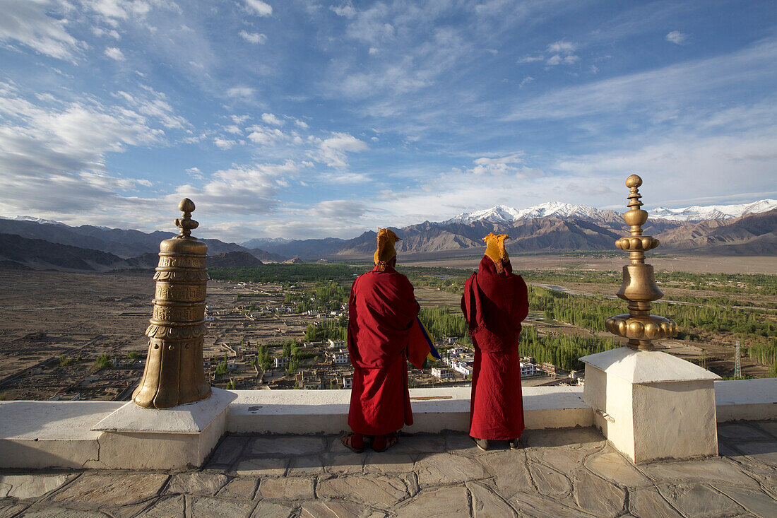 Buddhistische Mönche blasen Hörner auf dem Dach des Klosters Thikse oberhalb des Indus-Tals in den Himalaya-Bergen von Ladakh, Jammu und Kaschmir, Thiksey, Ladakh, Indien