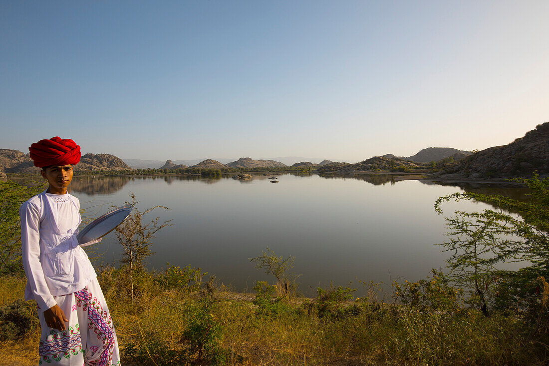 Man in red turban at lakeside near Narlai Village in rural Rajasthan,India