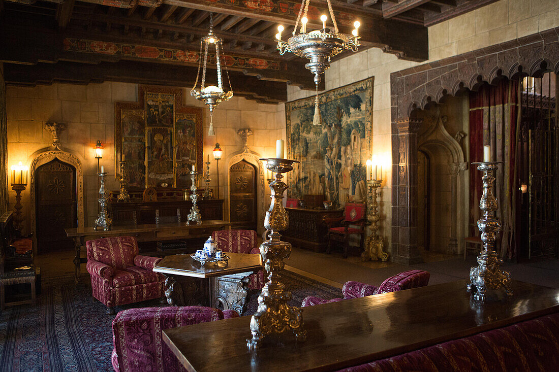 The Hearst Castle sitting room decorated with furniture,tapestries,artwork,ornate candles and light fixtures.,Hearst Castle,San Simeon,California