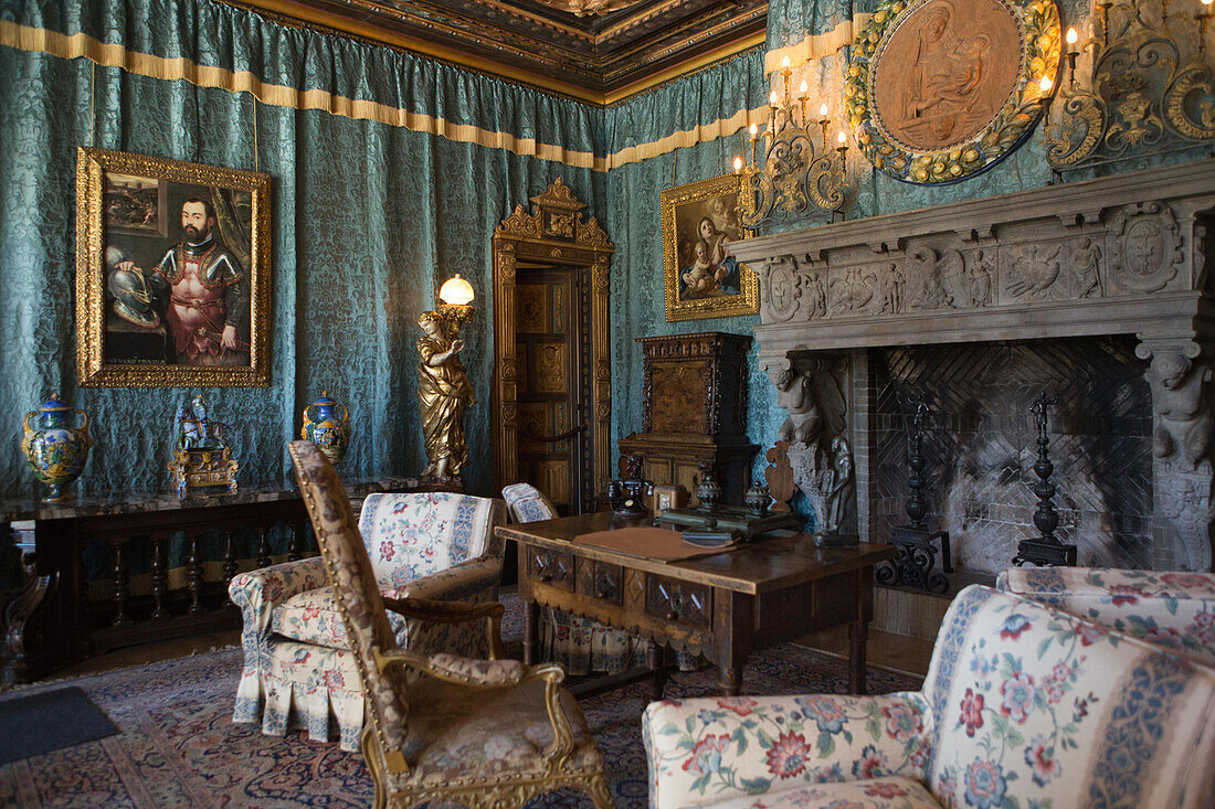 Ein Wohnzimmer mit Kamin, dekoriert mit Möbeln, Wandteppichen, Kunstwerken und kunstvollen Beleuchtungskörpern,Hearst Castle,San Simeon,Kalifornien