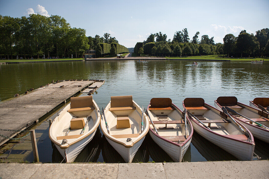 Boats for rent sit at the dock in the Grand Canal at Versailles.,Versailles,France