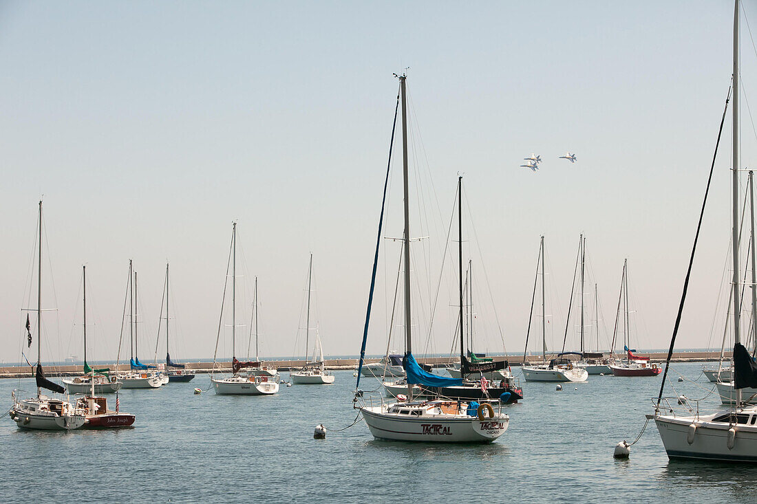 The Blue Angels fly in formation above Lake Michigan and sailboats docked in Chicago Harbors.,Chicago,Illinois