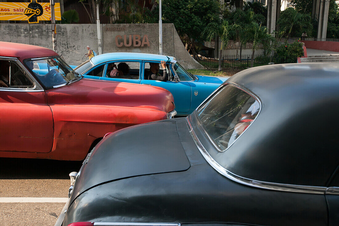 Several colorful,classic American cars line a street in downtown Havana.,Havana,Cuba