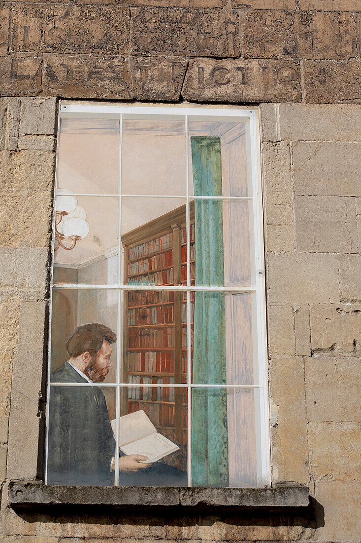 Mural painted on the facade of a house of a man looking at a book in his home library in Bath,England,Bath,Somerset,England