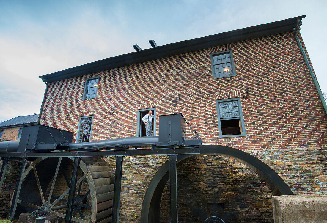 Der Müller sieht zu, wie die Räder in der Aldie-Mühle in Loudoun County, Virginia, das Wasser drehen.