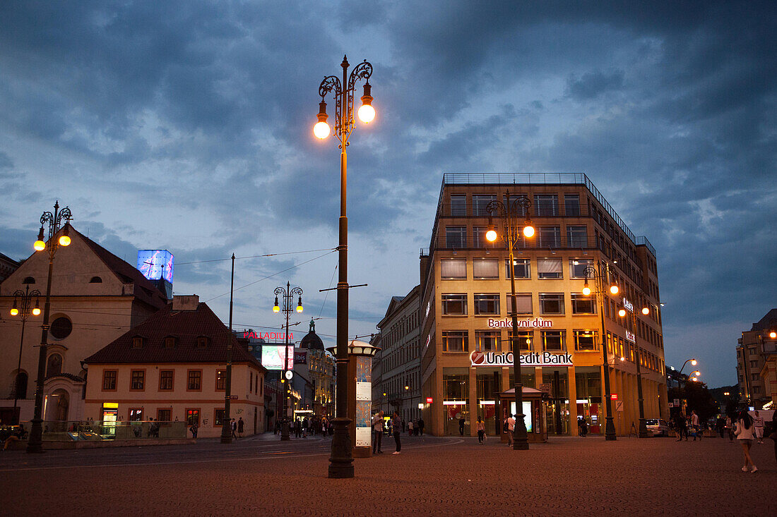 Lights illuminate the stores and buildings in Prague's Republic Square.,Prague,Czech Republic