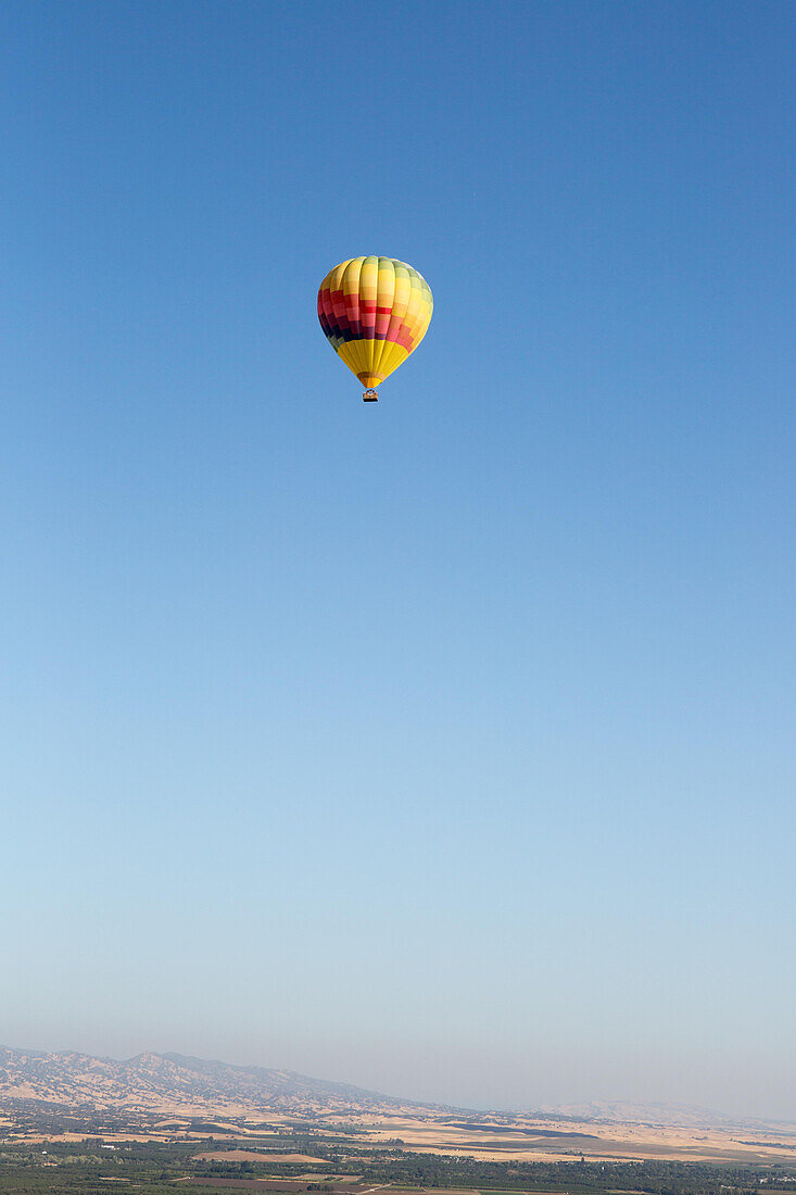 A hot air balloon flies over California,east of Napa Valley.,Winters,California