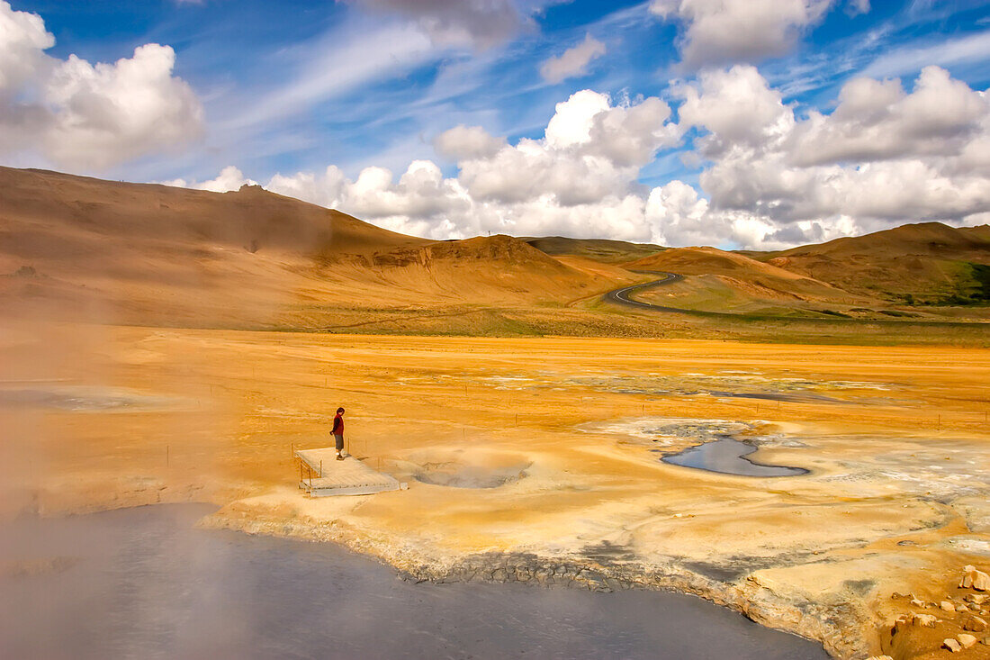 Tourist observing boiling mud pits,a source of alternative enegry.