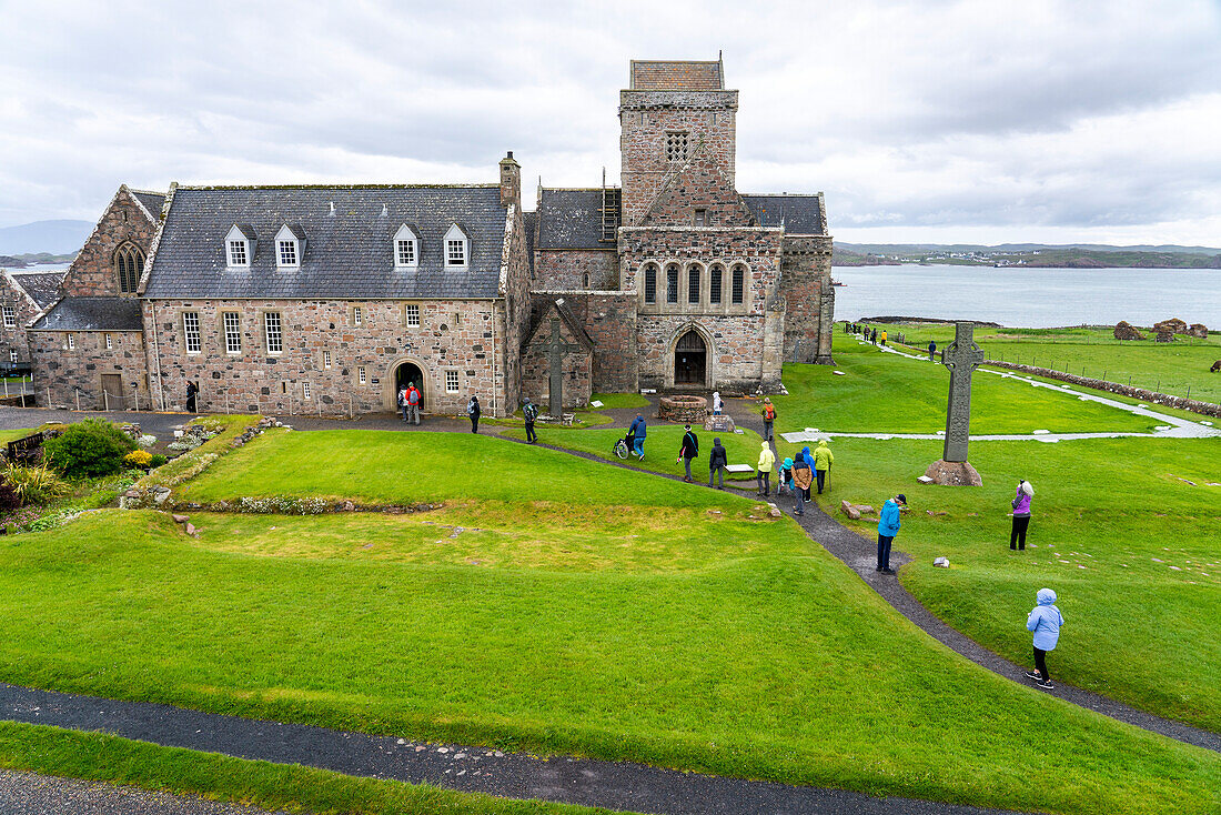 Besucher erkunden das Gelände der ehemaligen Benediktinerabtei auf der Isle of Iona, Schottland, Iona, Isle of Iona, Schottland