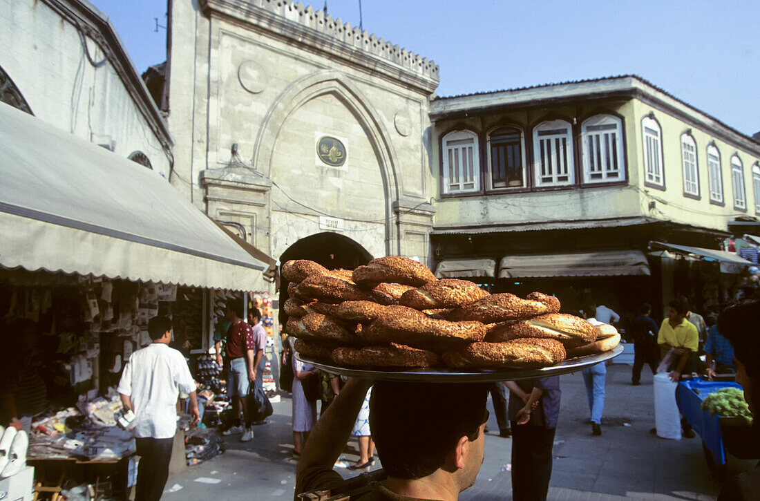 A food vendor carrying a plate of bagels on his head.,Istanbul,Turkey.