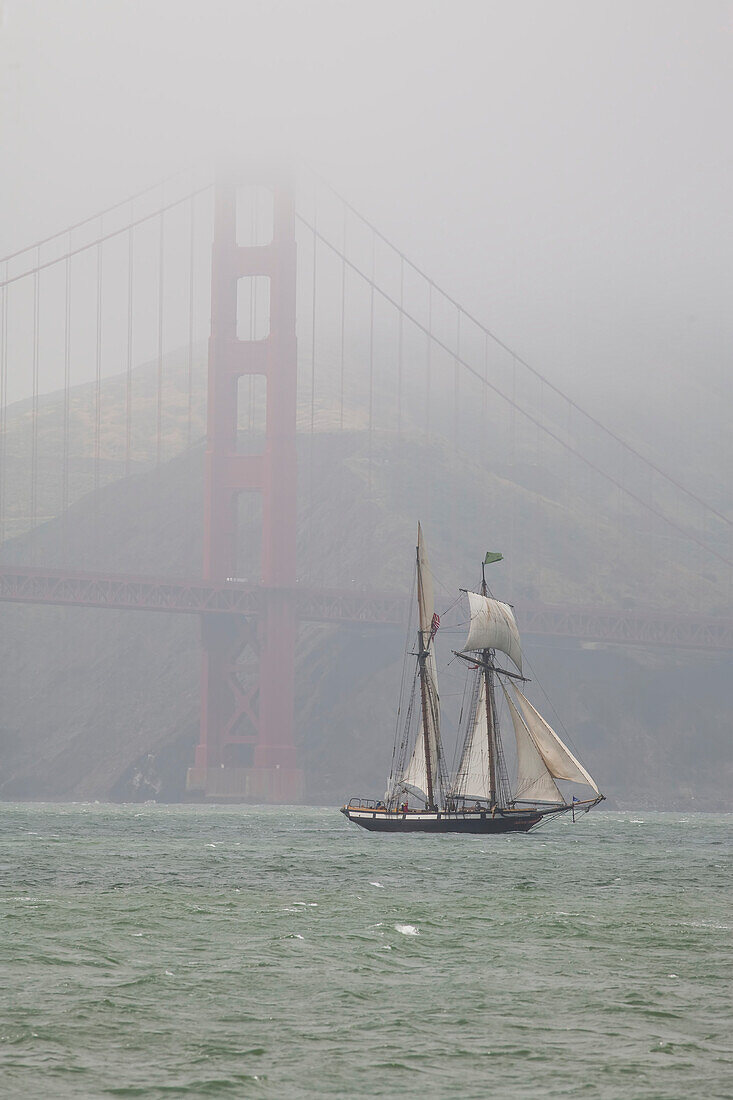 Ein Zweimastschoner segelt unter der Golden Gate Bridge hindurch,San Francisco,Kalifornien.