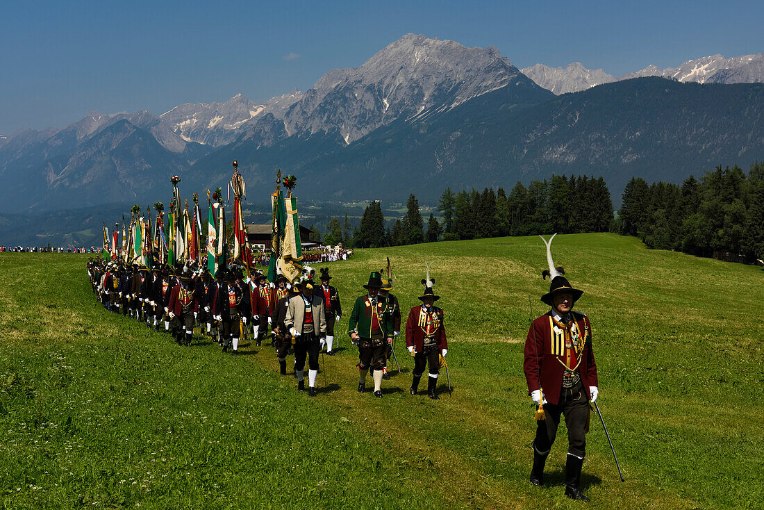 Der Festzug zum Herz-Jesu-Fest betritt eine große Wiese am Fuße des Karwendelgebirges.