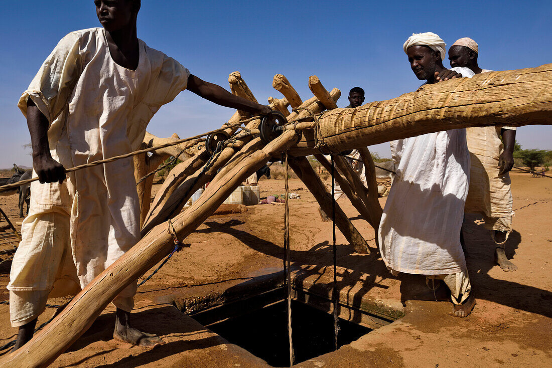 Sudanese farmers collect water from a deep well close to the archeological site at Naqa.,Naqa,Sudan,Africa.