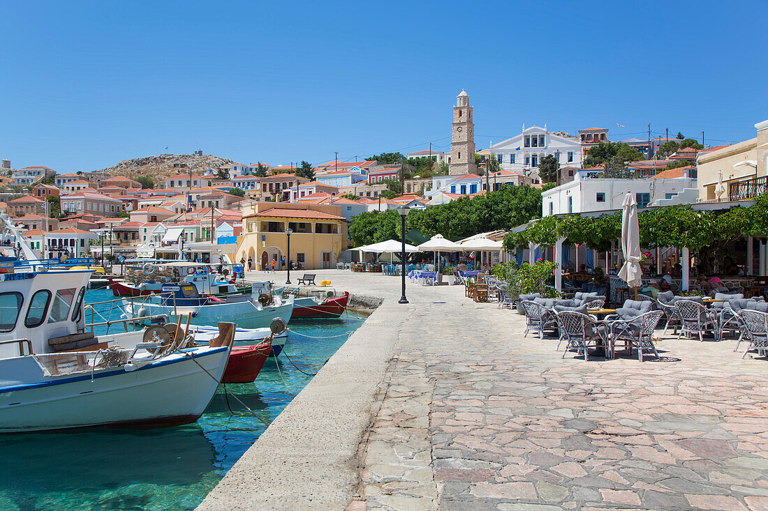 Moored boats and restaurant patio at Emporio Harbor,Emporio,Halki,Dodecanese,Greece