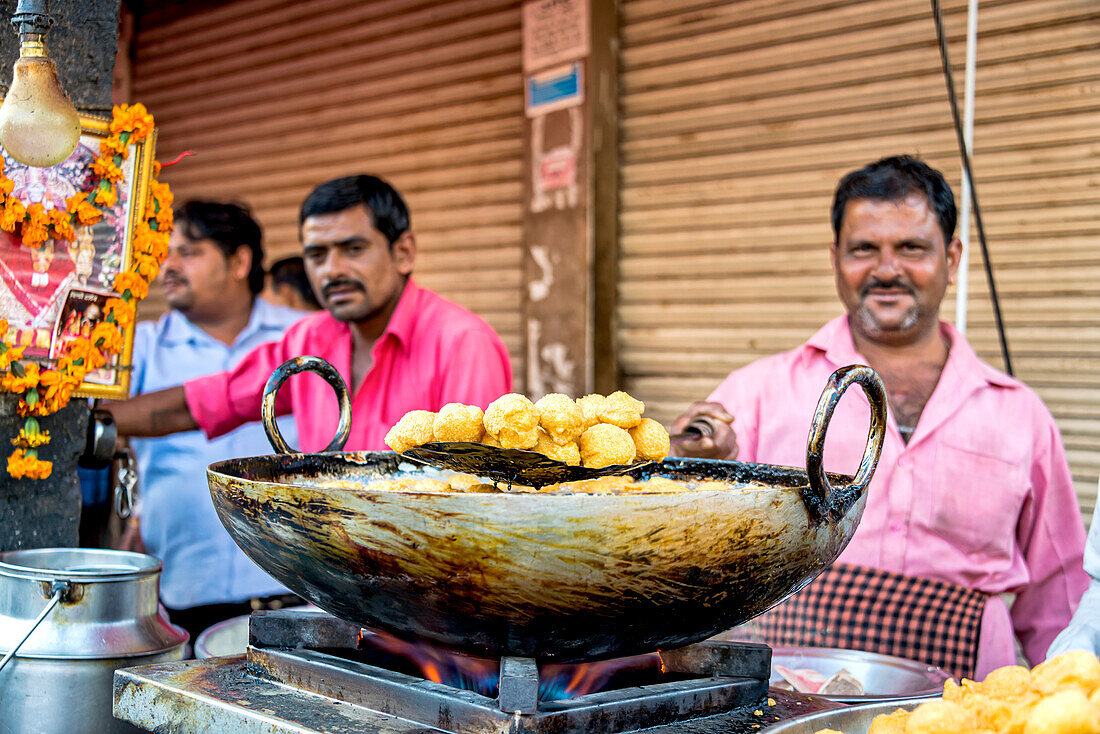 Männer verkaufen Lebensmittel auf einem Straßenmarkt in Indien, Dehli, Indien