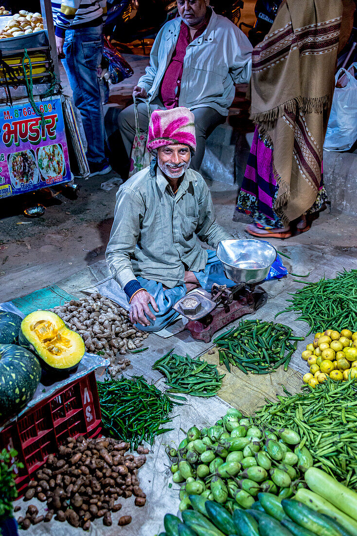 Vendor sitting cross-legged on the ground selling fresh produce on the street in India,Noida,Uttar Pradesh,India