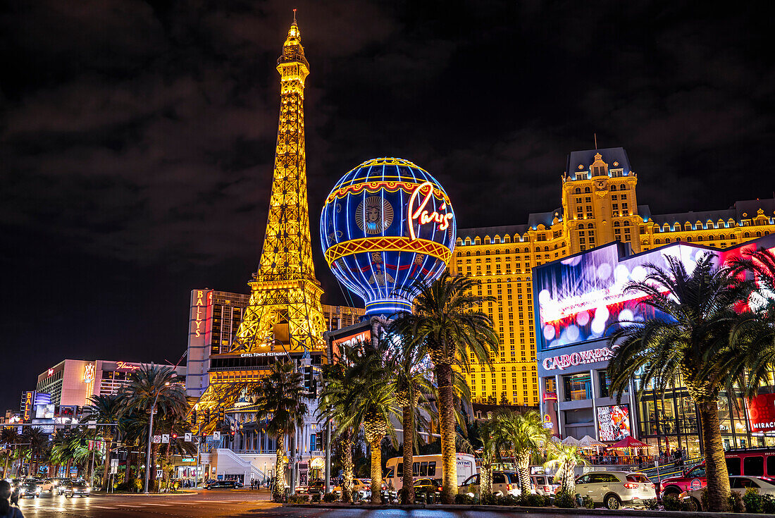 Szene entlang des Las Vegas Strip bei Nacht mit beleuchteten Gebäuden und Strukturen, Las Vegas, Nevada, Vereinigte Staaten von Amerika