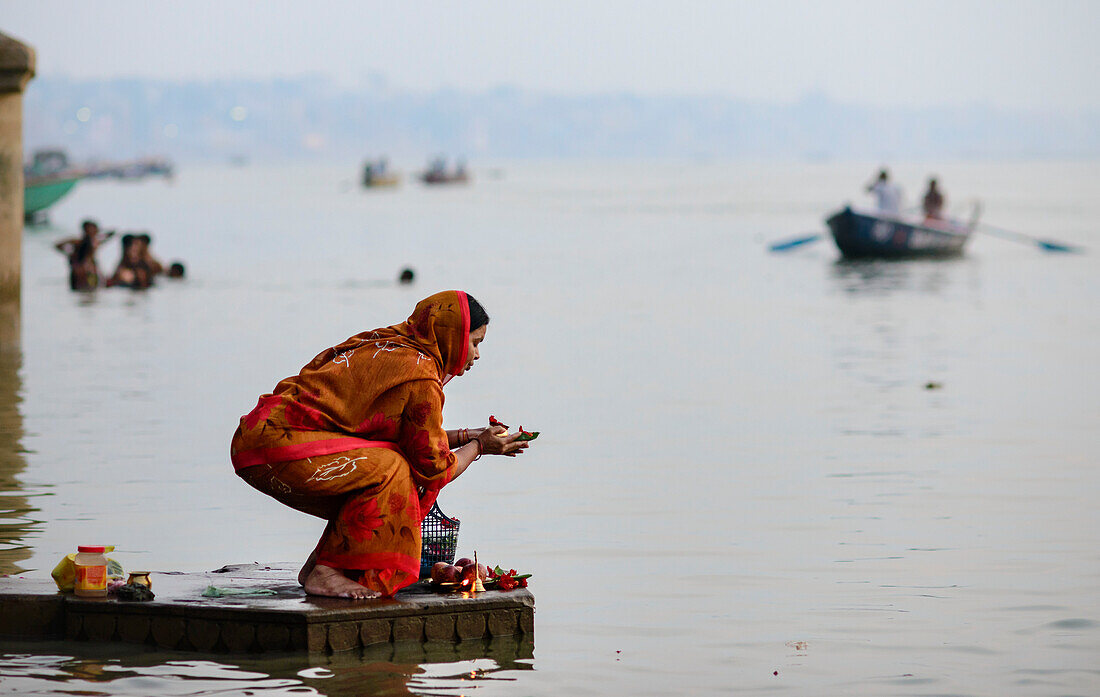 Devotee bei einer Opfergabe auf dem Ganges, Varanasi, Indien