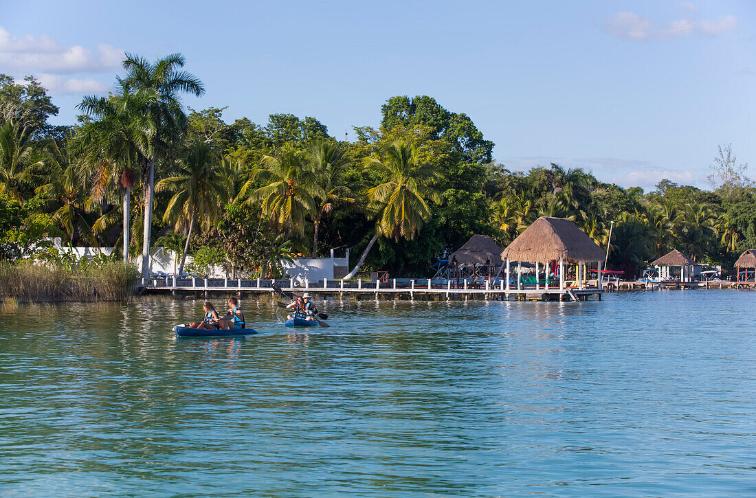 Docks an der Lagune von Bacalar, Mexiko, mit Touristen, die Freizeitaktivitäten genießen, Bacalar, Staat Quintana Roo, Mexiko