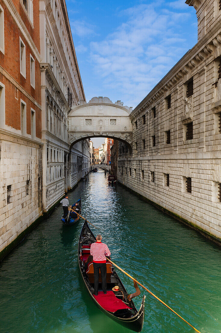 Gondoliere paddeln in ihren Gondeln mit Touristen unter der Seufzerbrücke in einem Kanal, Venedig, Venetien, Italien