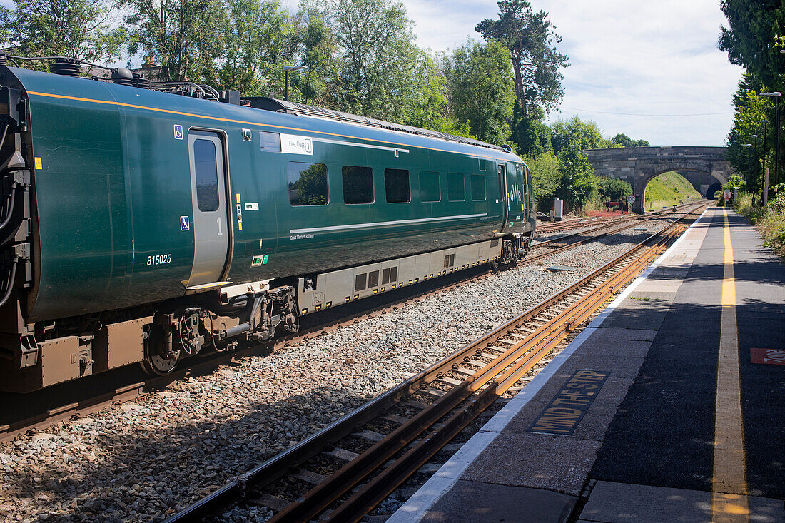 Green passenger train on the tracks at a station in The Cotswolds,UK,Ampney Crucis,Cotswolds,England