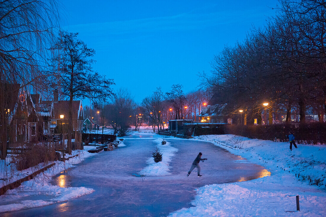 Ice skater alone on a canal at night,Amsterdam,Netherlands