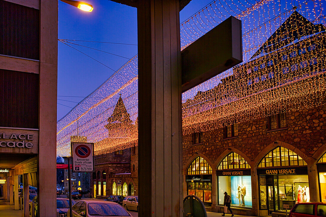 Streets are lit at dusk outside a plush hotel in St. Moritz. Glitzy designer shops attract high-end tourists for a glamorous vacation in the Swiss Alps,St. Moritz,Switzerland