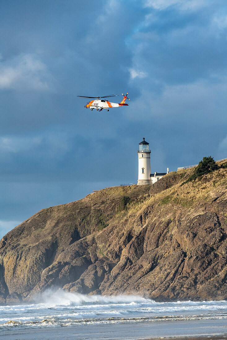 US Coast Guard helicopter flying near the Cape Disappointment North Head Lighthouse during a training mission,Ilwaco,Washington,United States of America