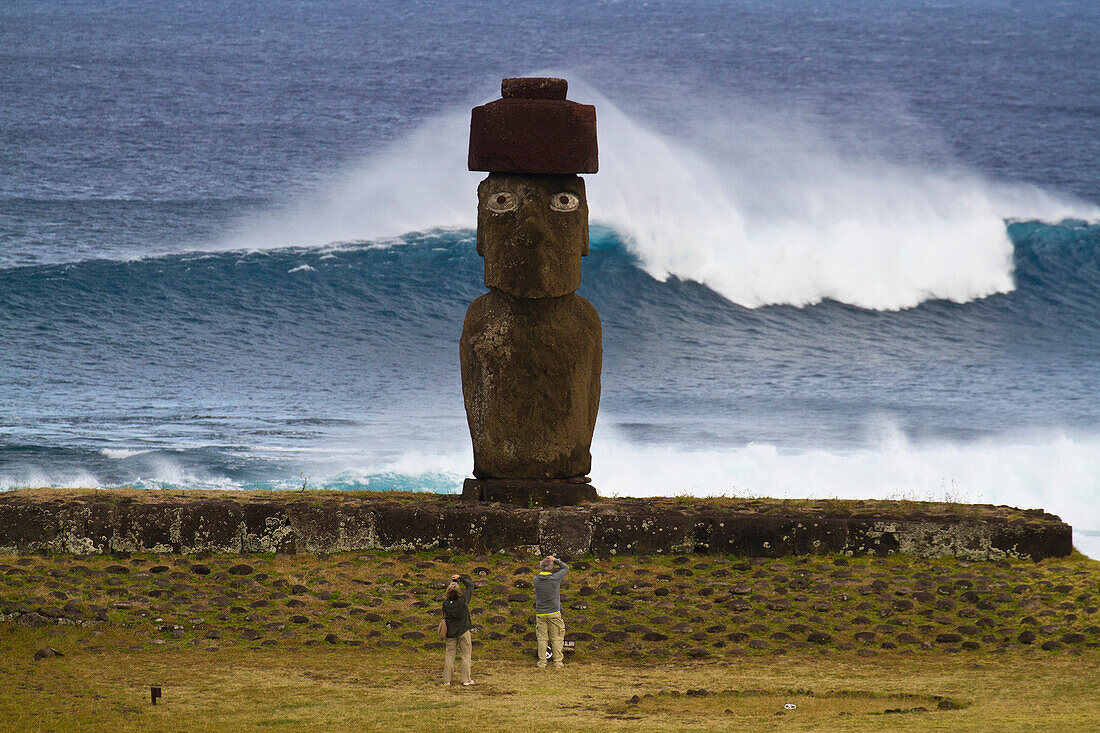 Touristen stehen vor einem Moai im Ahu Tahai Ceremonial complex, Rapa Nui National Park auf der Osterinsel, Osterinsel