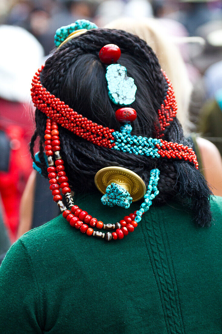 Rückansicht einer Person mit Kopfschmuck auf dem Borkhar-Markt, Lhasa, Tibet