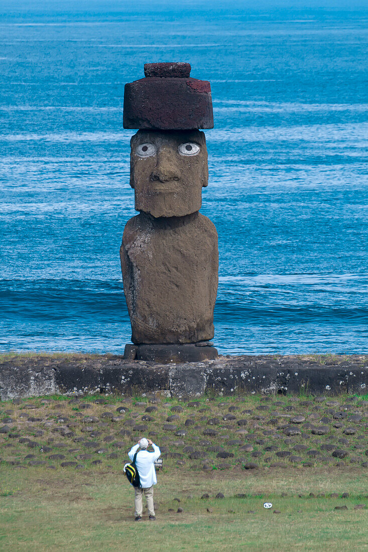 Tourist stands photographing the Ahu Ko Te Riku Moai at Rapa Nui National Park on Easter Island,Easter Island