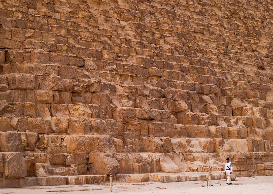 Mann geht am Sockel der Großen Pyramide von Gizeh vorbei,Gizeh,Ägypten