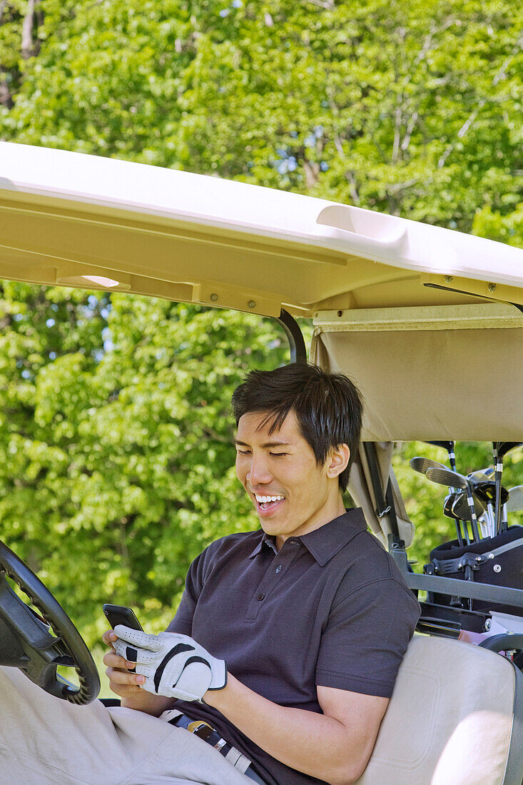 Man in Golf Cart Reading Text Message