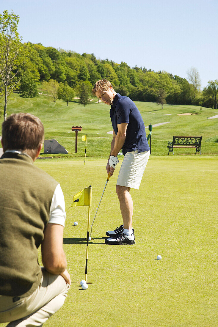 Golfer üben auf dem Putting Green