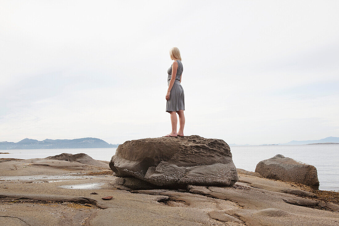Woman Standing on a Boulder on the Beach,Vancouver,BC,Canada