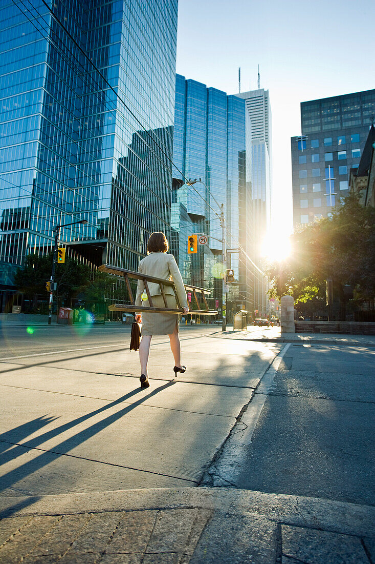 Businesswoman Crossing Street and Carrying Ladder