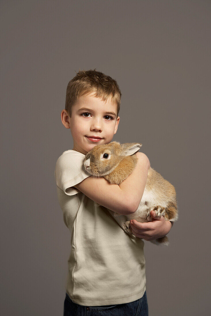 Porträt eines Jungen, der ein Kaninchen hält