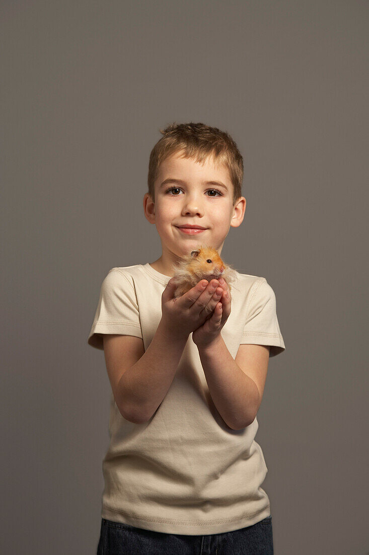 Kleiner Junge hält Hamster