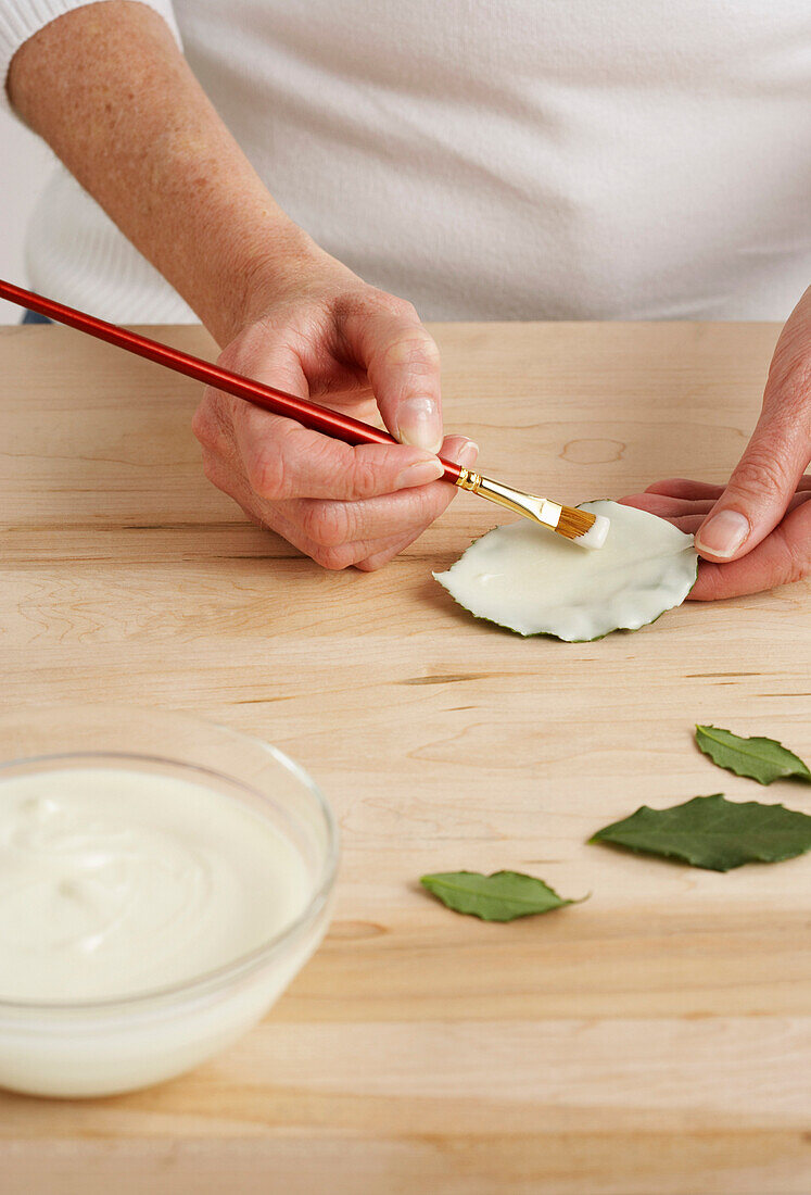 Person Making White Chocolate Leaves
