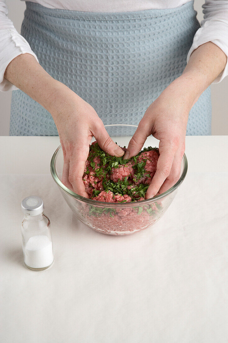 Woman Mixing Beef and Ingredients to Make Hamburgers