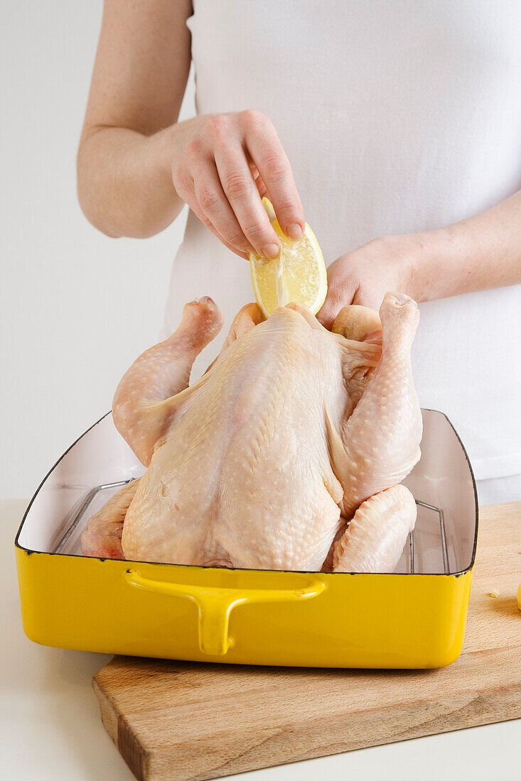 Woman Stuffing Chicken With Lemon and Garlic