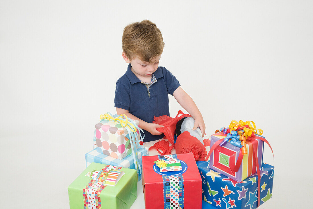 Kleiner Junge öffnet Geburtstagsgeschenke