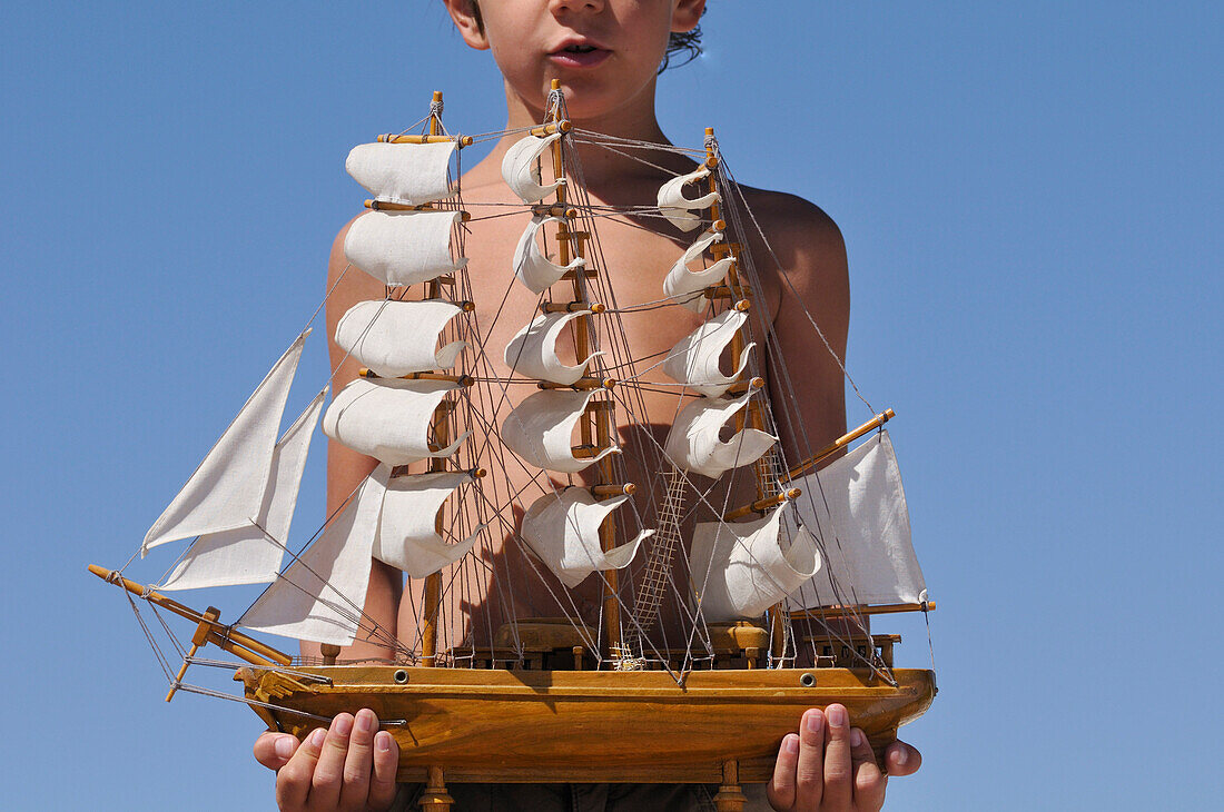 Boy Holding Model Ship
