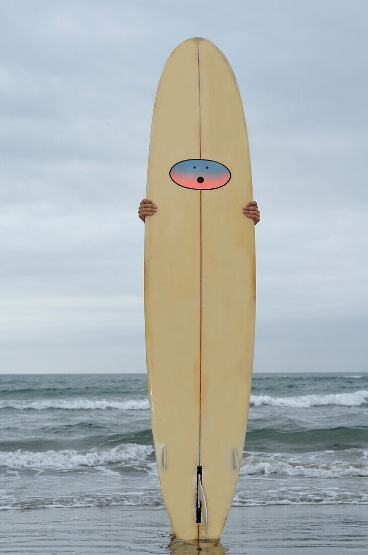 Man Holding Surfboard on Beach