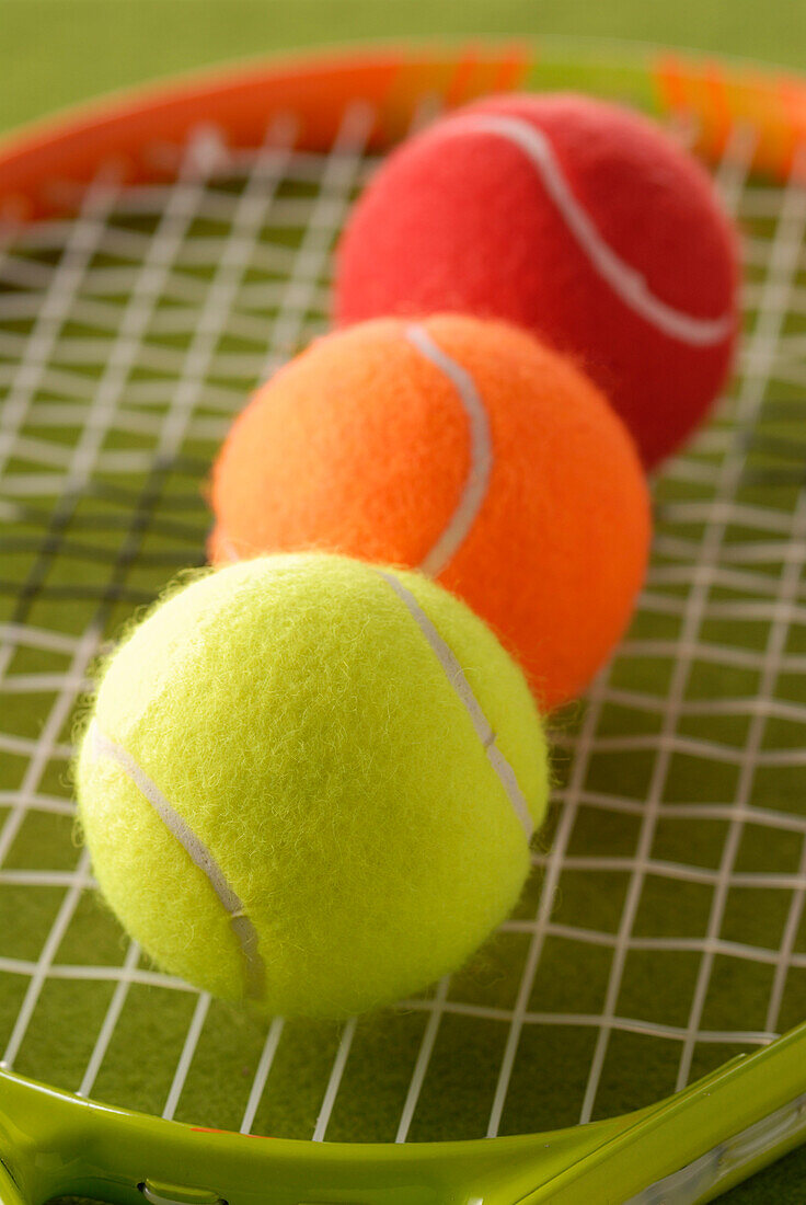 Drei Tennisbälle auf einem Schläger