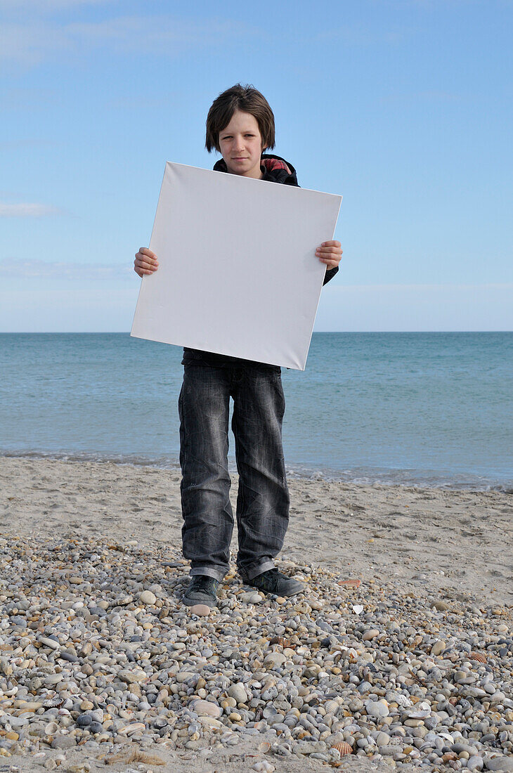 Boy Holding Blank Canvas on Beach,Sete,France